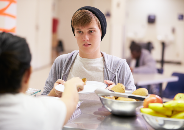 [A young person gets food from a homeless shelter]