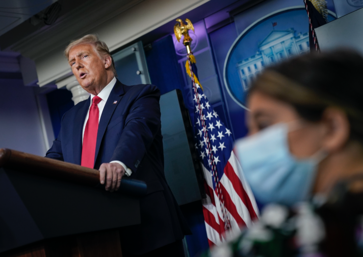 [PHOTO: Trump speaking behind a podium]