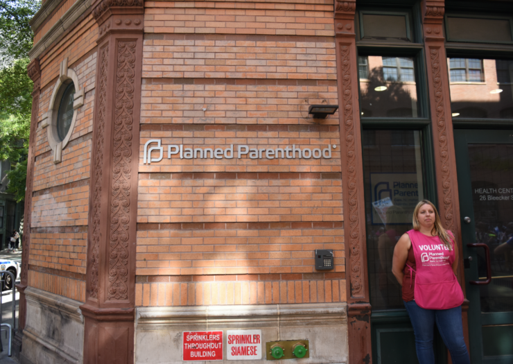 [PHOTO: Volunteer woman stands outside Planned Parenthood building in New York City]