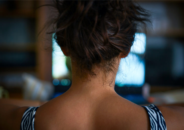 [PHOTO: Back of woman sitting behind a laptop]