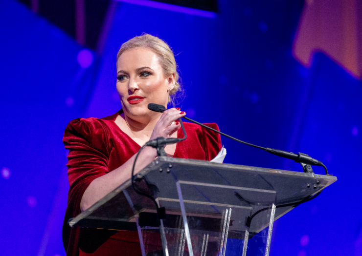 [PHOTO: Meghan McCain stands behind a podium touching the microphone]