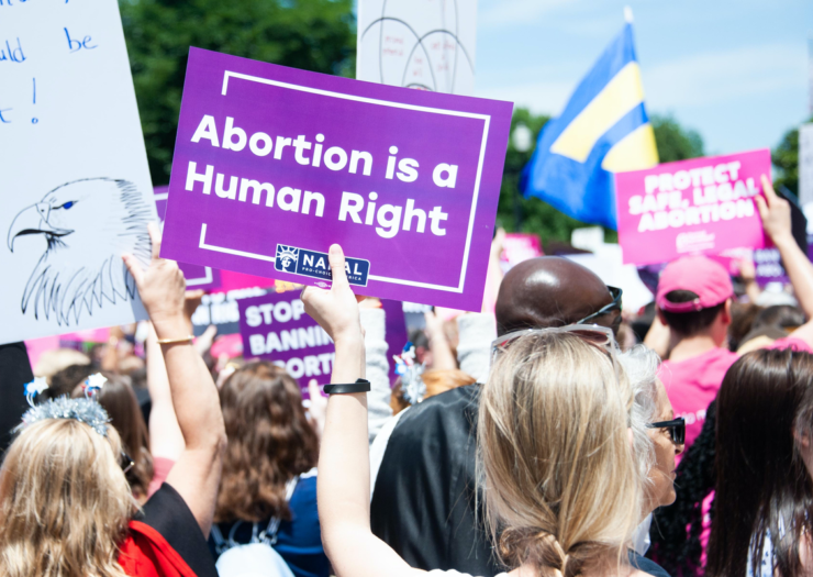 [PHOTO: Purple sign being held up that says 'Abortion is a human right']