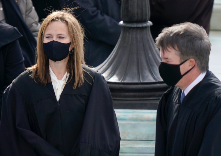 [PHOTO: Justices Amy Coney Barrett and Brett Kavanaugh wearing black robes and masks]