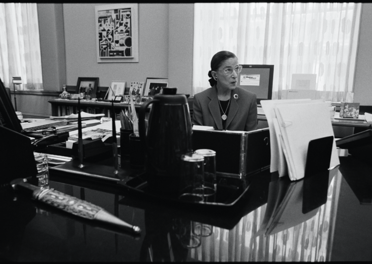 [PHOTO: Black and white photo of Ruth Bader Ginsburg behind a desk]
