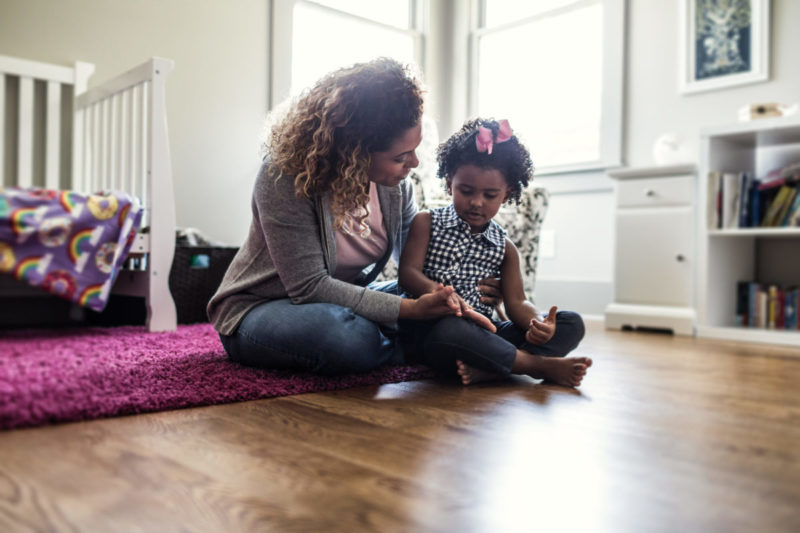 Mom sitting on the floor with child in child's bedroom