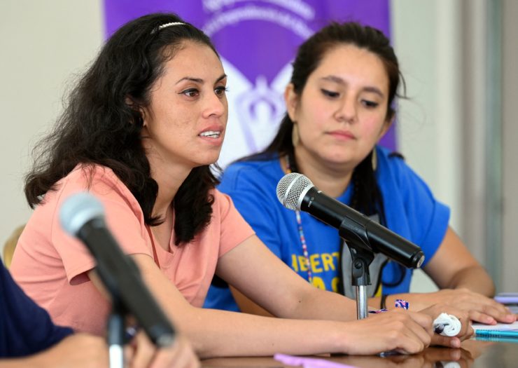 Sara Rogel sits behind a microphone during a press conference after being released from prison