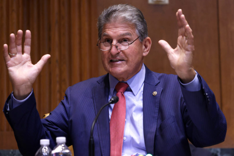 Photo of Senator Joe Manchin holds his hands up as he speaks
