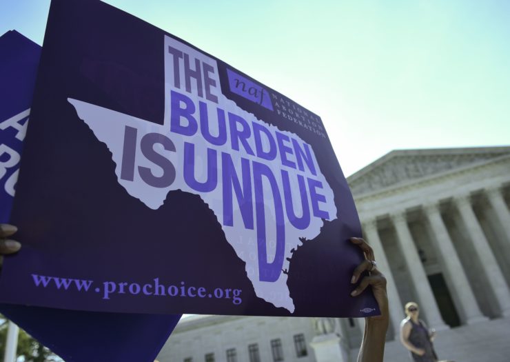 Photo of a sign that reads The Burden Is Undue in the shape of Texas
