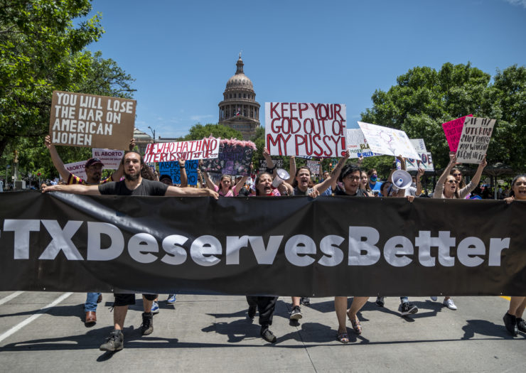 Photo of protesters holding a sign that reads TX Deserves Better