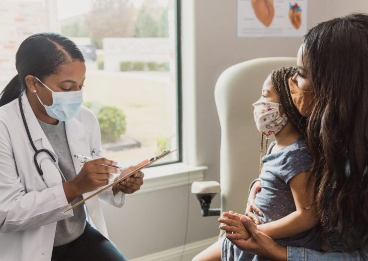 Photo of Black woman and her kid at the doctor's office