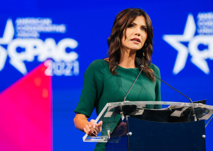Photo of South Dakota governor Kristi Noem speaking behind a podium at a CPAC conference