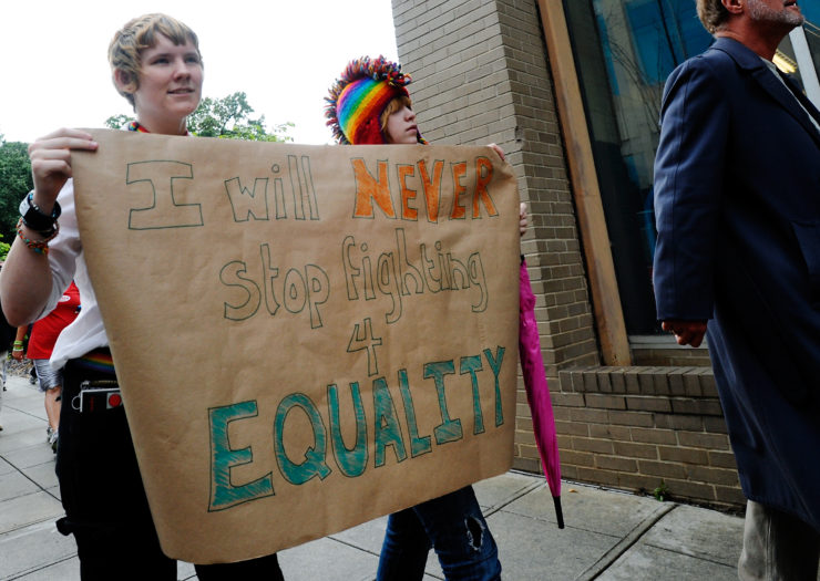 Protesters from Occupy Raleigh hold a big sign that reads I will never stop fighting for equality
