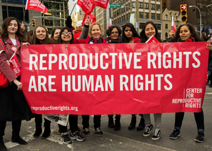 [Photo of members of the Center for Reproductive Rights holding a red banner that says Reproductive Rights Are Human Rights]