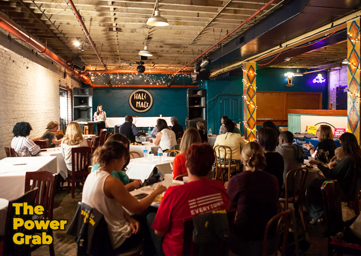 Photo of Ashley Peterson speaking at a podium with an audience sitting in tables