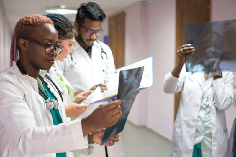Photo of four med school students of color looking over x-rays