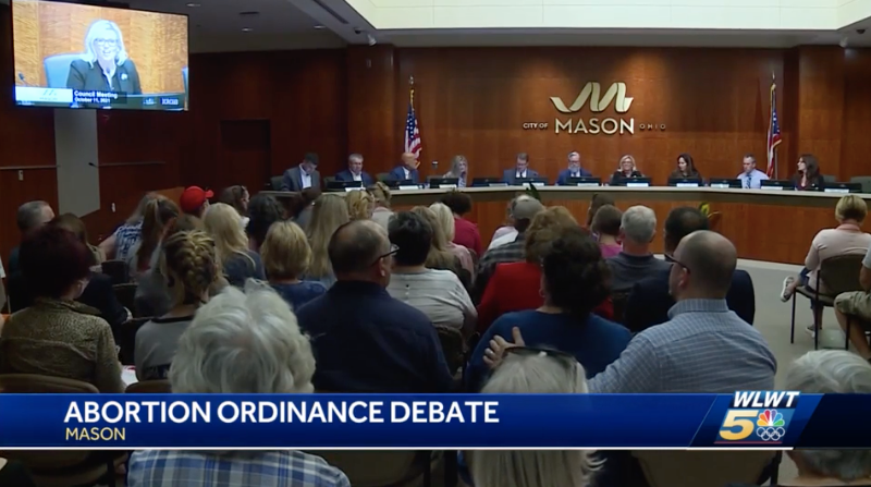 [Screengrab of a packed city council meeting on local news, and a chyron says: Abortion ordinance debate - Mason.