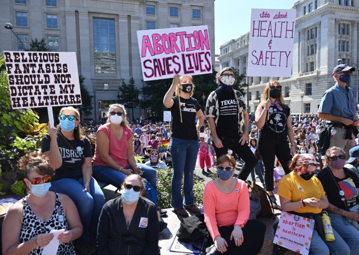 Photo of a group of abortion rights protesters, both standing and sitting down