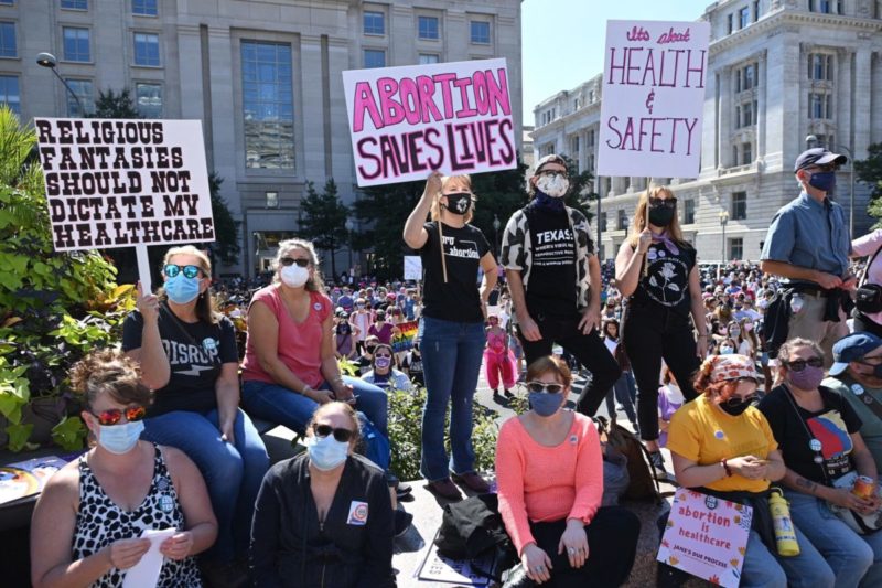 Photo of a group of abortion rights protesters, both standing and sitting down