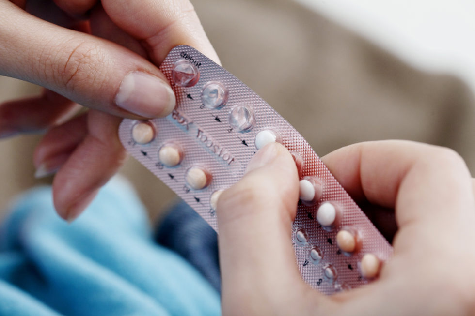 Photo of woman's hands holding a pack of contraceptive pills
