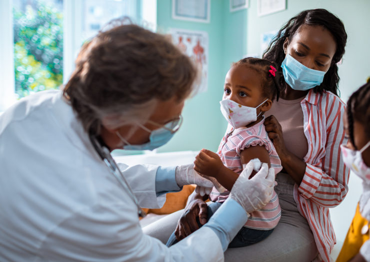 Photo of doctor examining a child with her mother