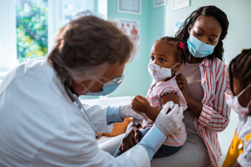 Photo of doctor examining a child with her mother