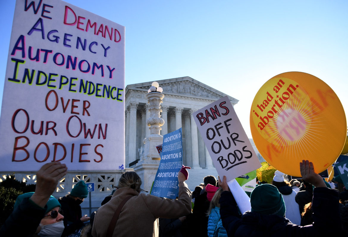Photo of abortion rights protesters outside the Supreme Court holding signs