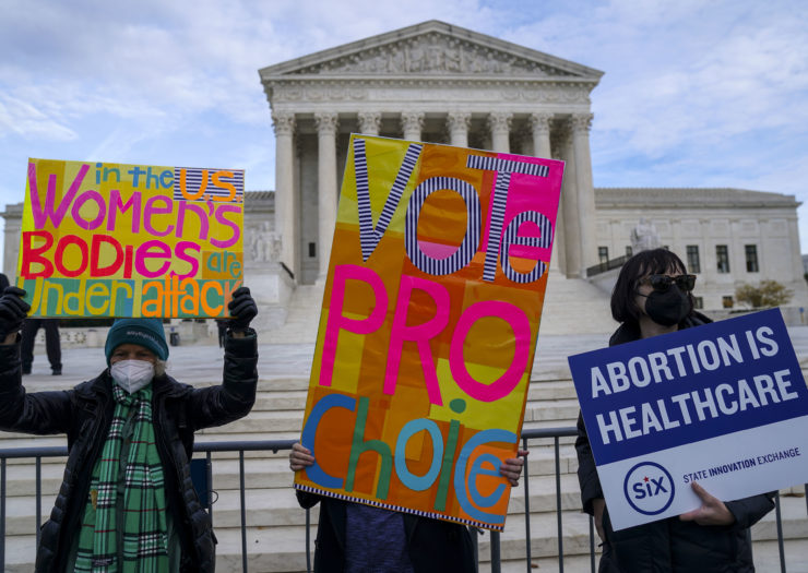 Photo of abortion and voting rights protesters holding signs outside the Supreme Court
