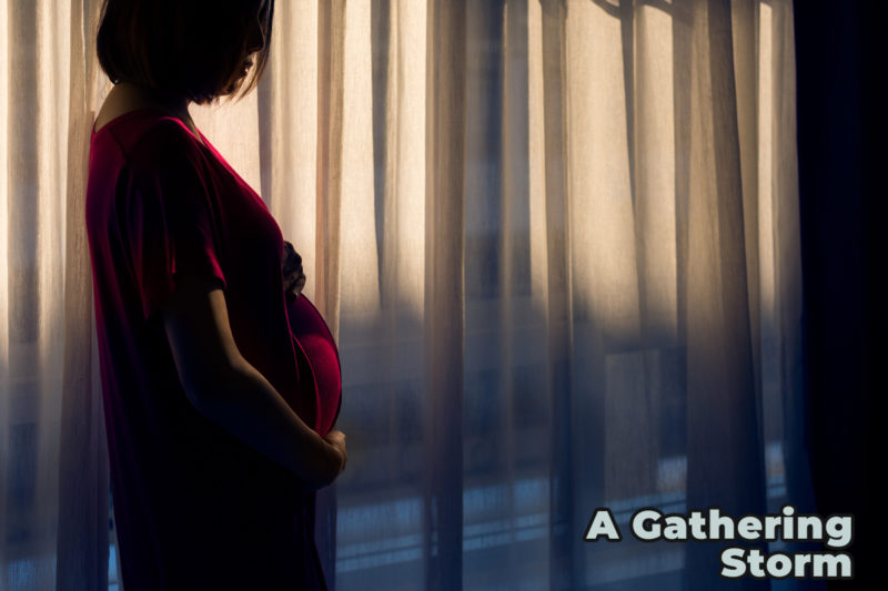 Photo of pregnant woman in the shadows of dimly lit room