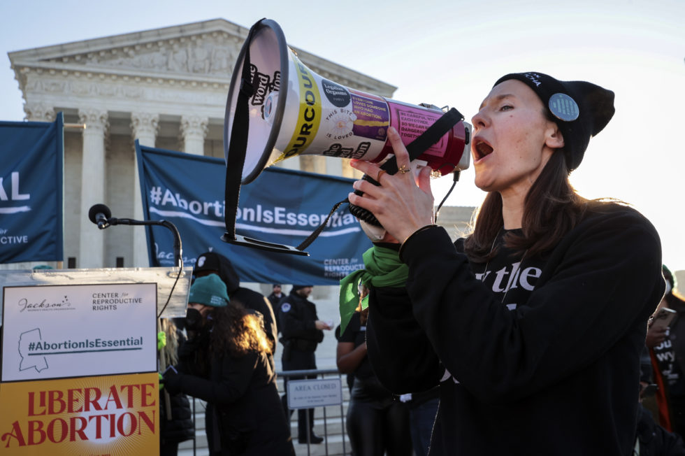 Photo of abortion rights protester with a megaphone in front of the Supreme Court