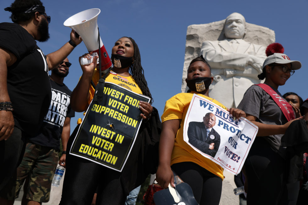 Photo of people holding signs at a voting rights rally