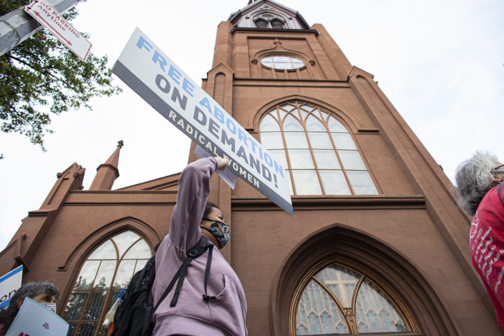 Photo of protesters outside NYC Catholic church holding sign that reads Free Abortion on Demand!