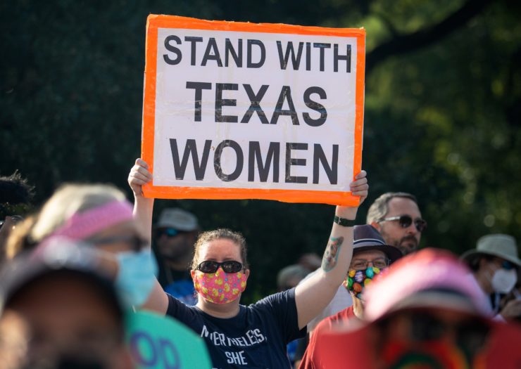 Photo of person holding sign that reads Stand With Texas Women