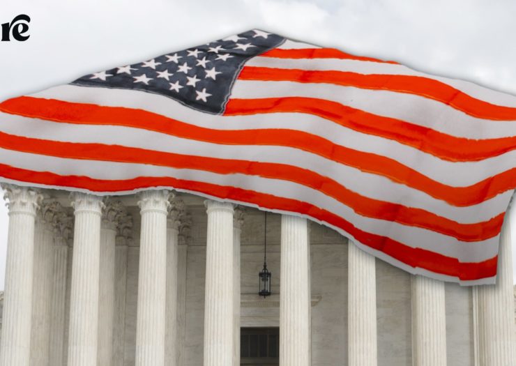 The Supreme Court building covered at the top with an American flag