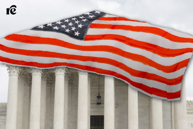 The Supreme Court building covered at the top with an American flag