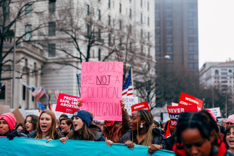 photo of protesters holding a sign that says Our bodies are not a political playground