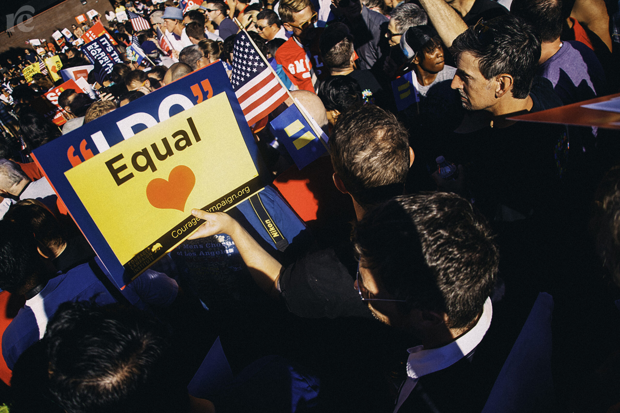 Photo of a demonstration with someone holding up a sign that says Equal with a red heart