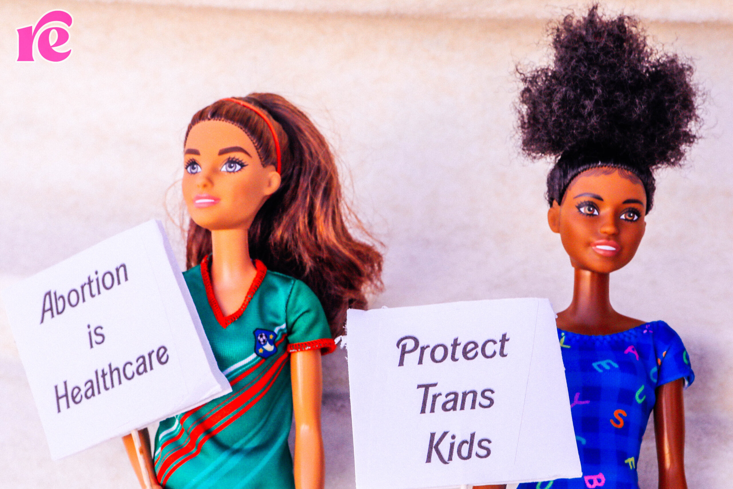 2 Barbies with trans rights signs