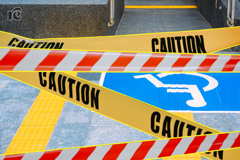 Photo of sidewalk with wheelchair sign and caution tape