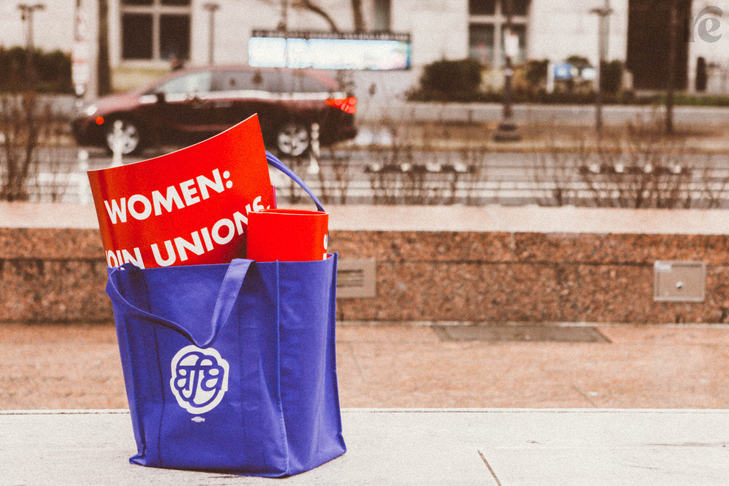 Purple tote bag holding red pro-union signs