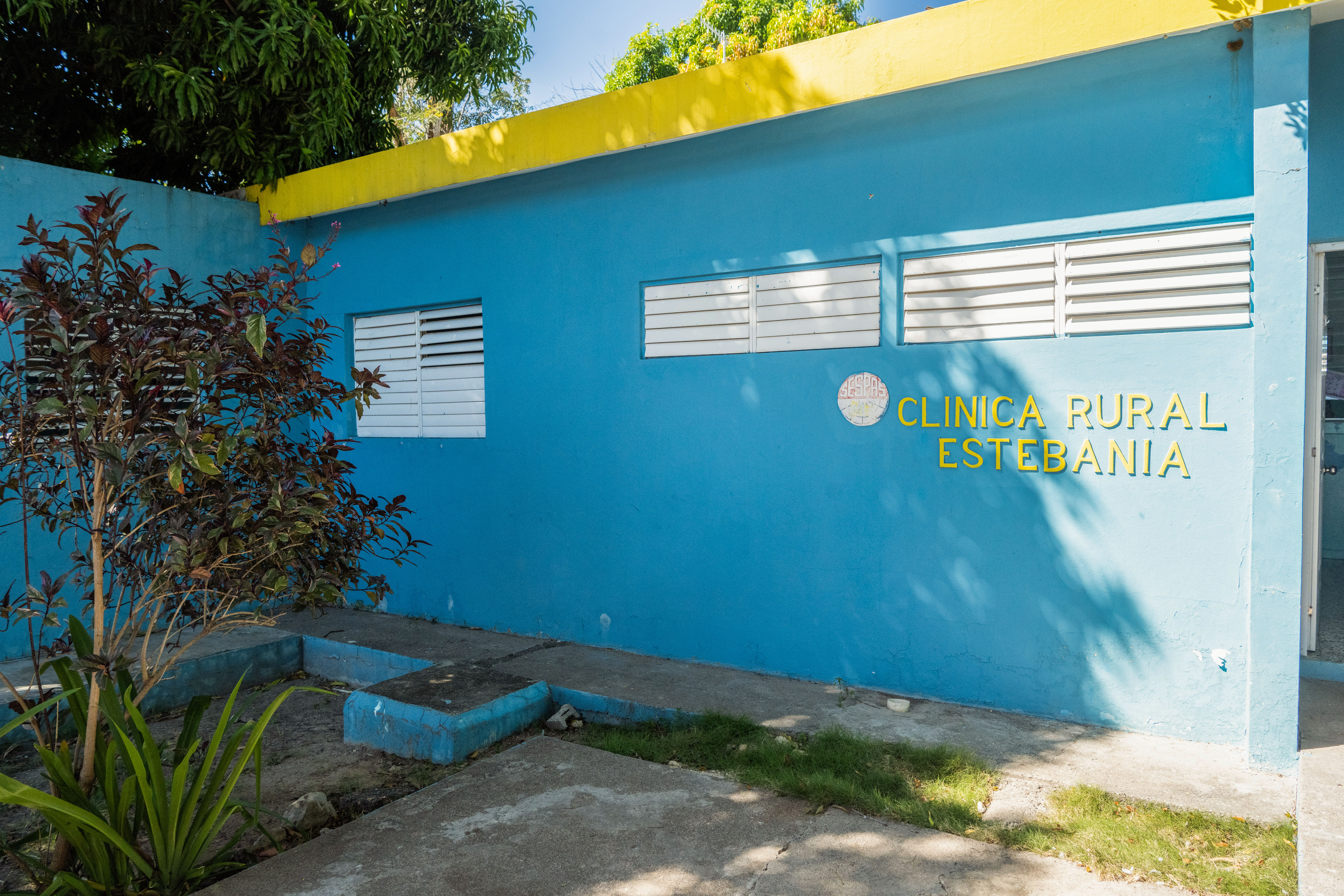 Light blue building that says Clinica Rural Estebania in yellow 