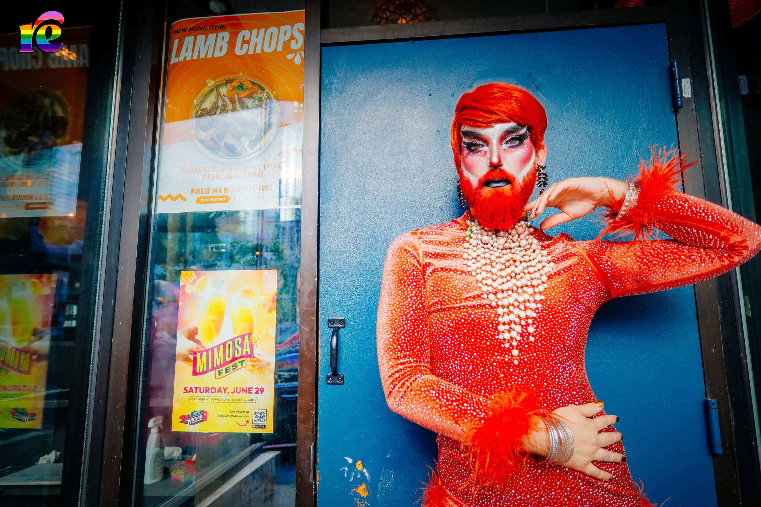 drag queen dressed in orange outside blue door