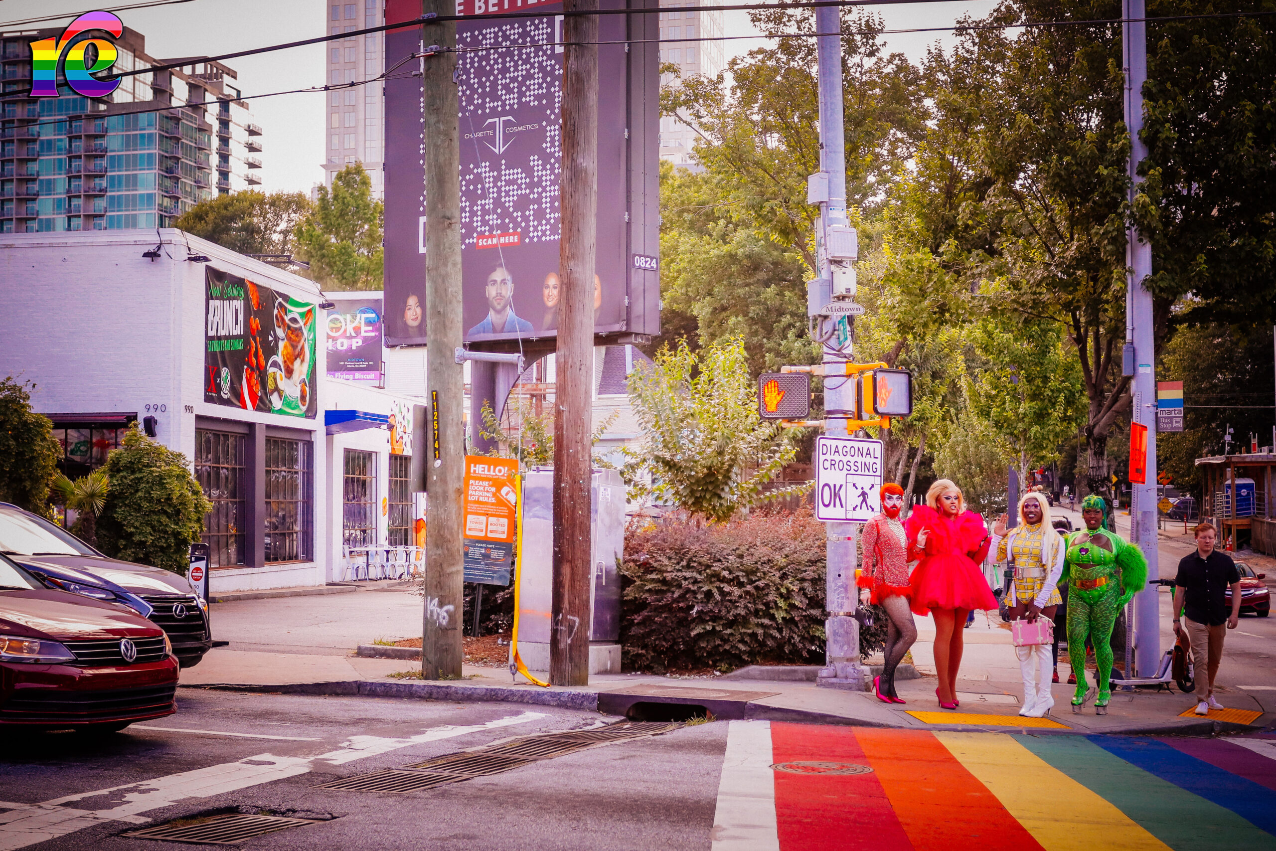 four drag queens standing at rainbow crosswalk
