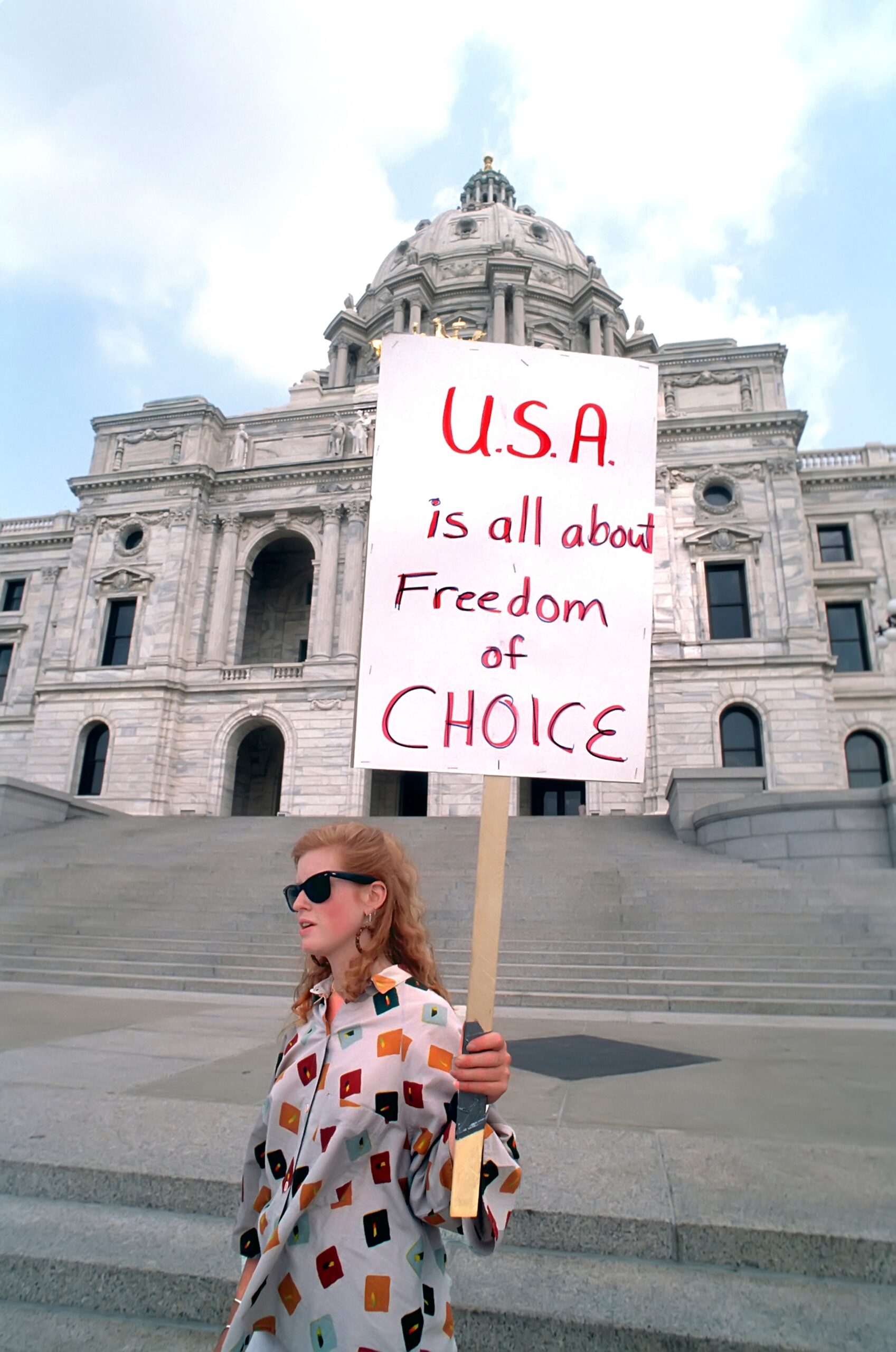 Woman holding sign that reads USA is all about freedom of choice