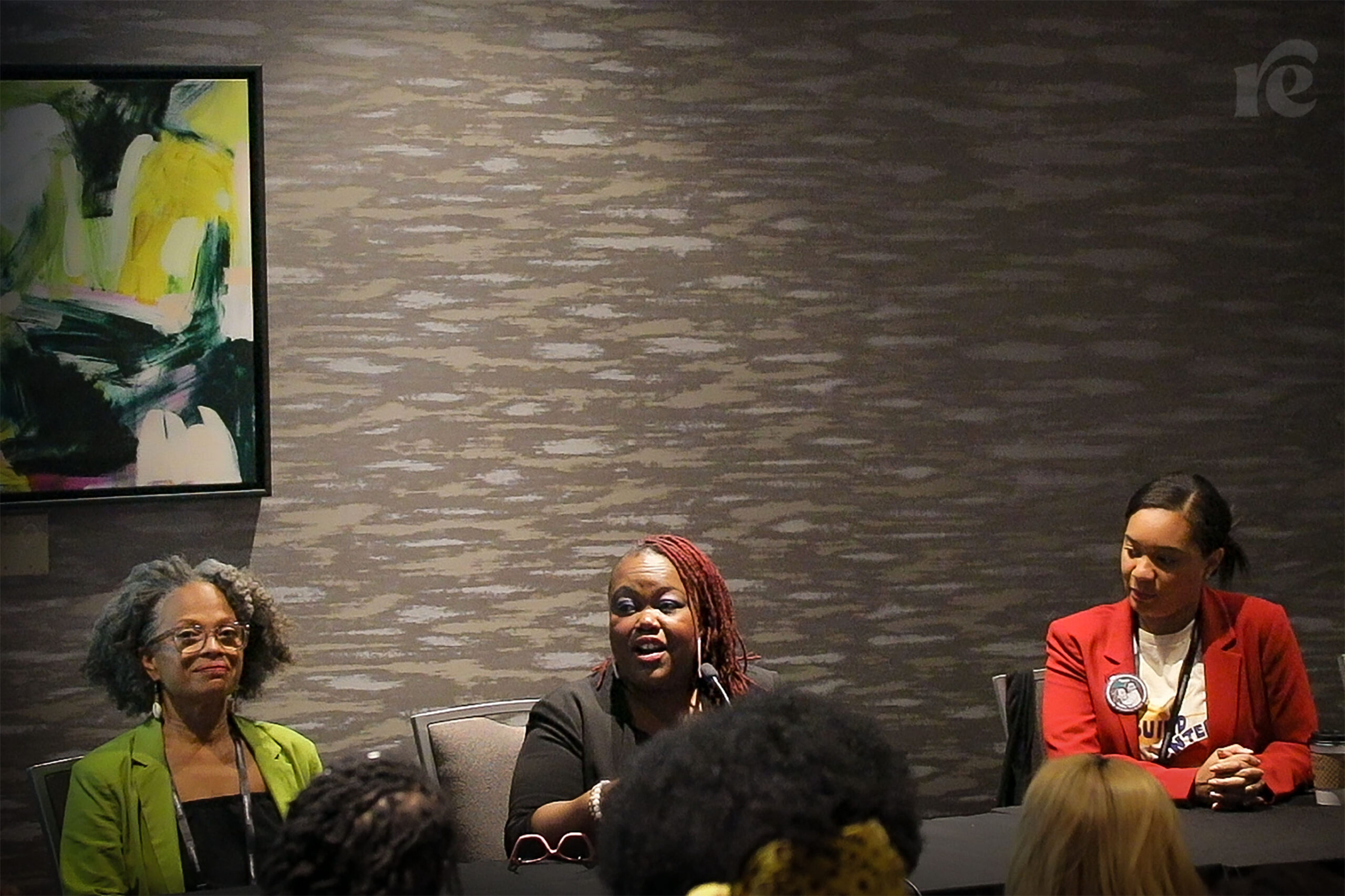 Three Black woman speaking on a panel