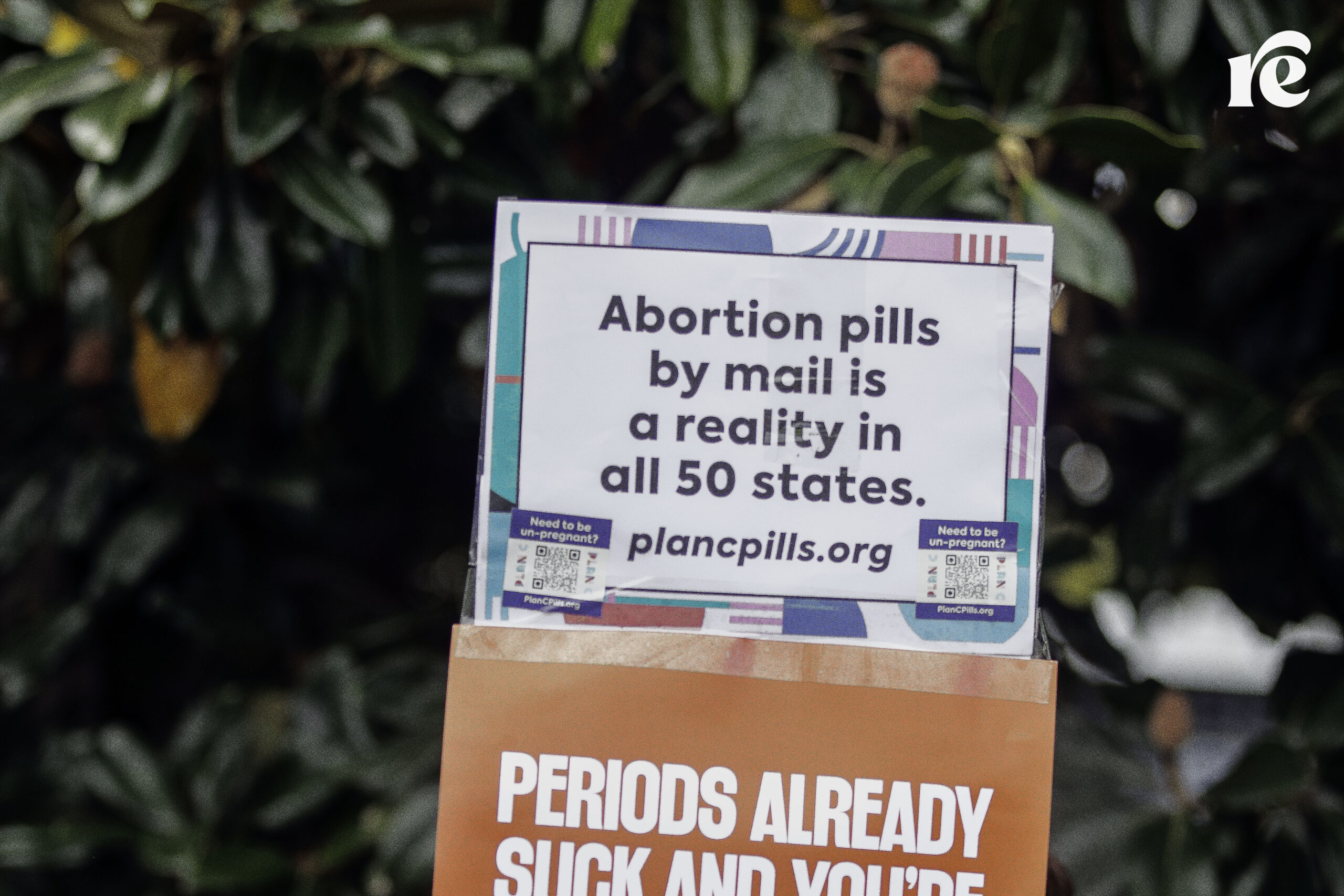 A sign reading, "Aboartion pills by mail is a reality in all 50 states. plancpills.org"