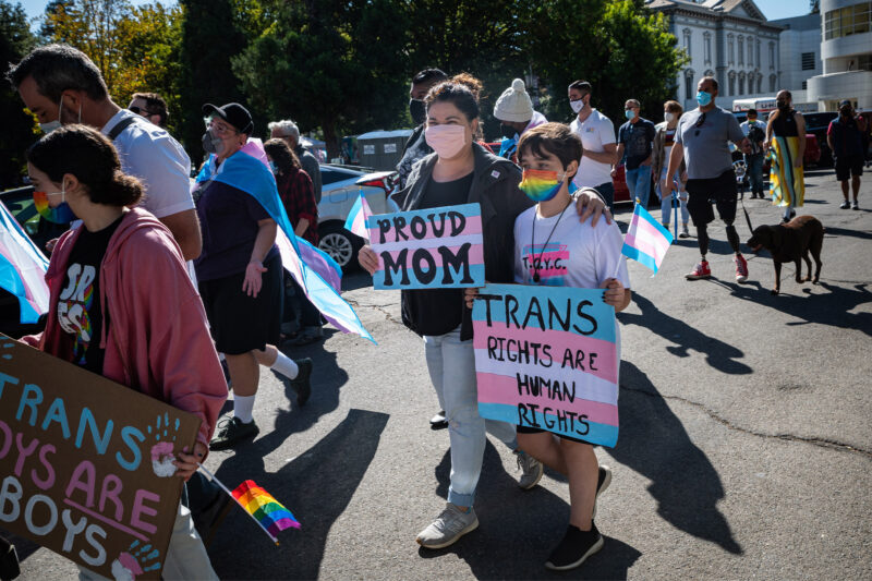 A mother and child, march with Proud Mom and Trans Rights are Human Rights signs during the National Trans Visibility March.