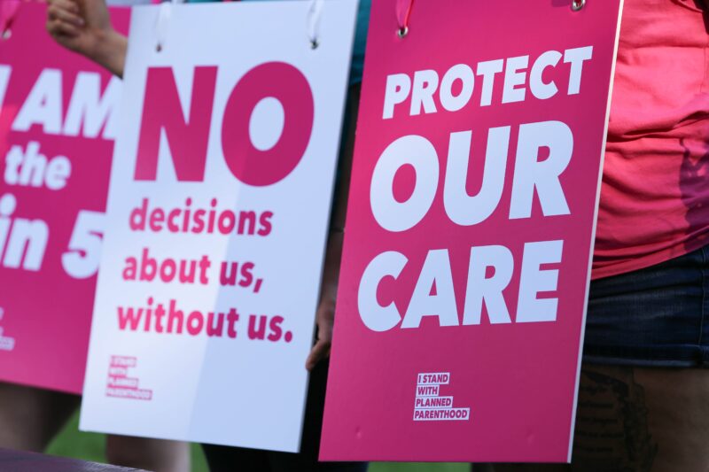Two pink and white signs reading